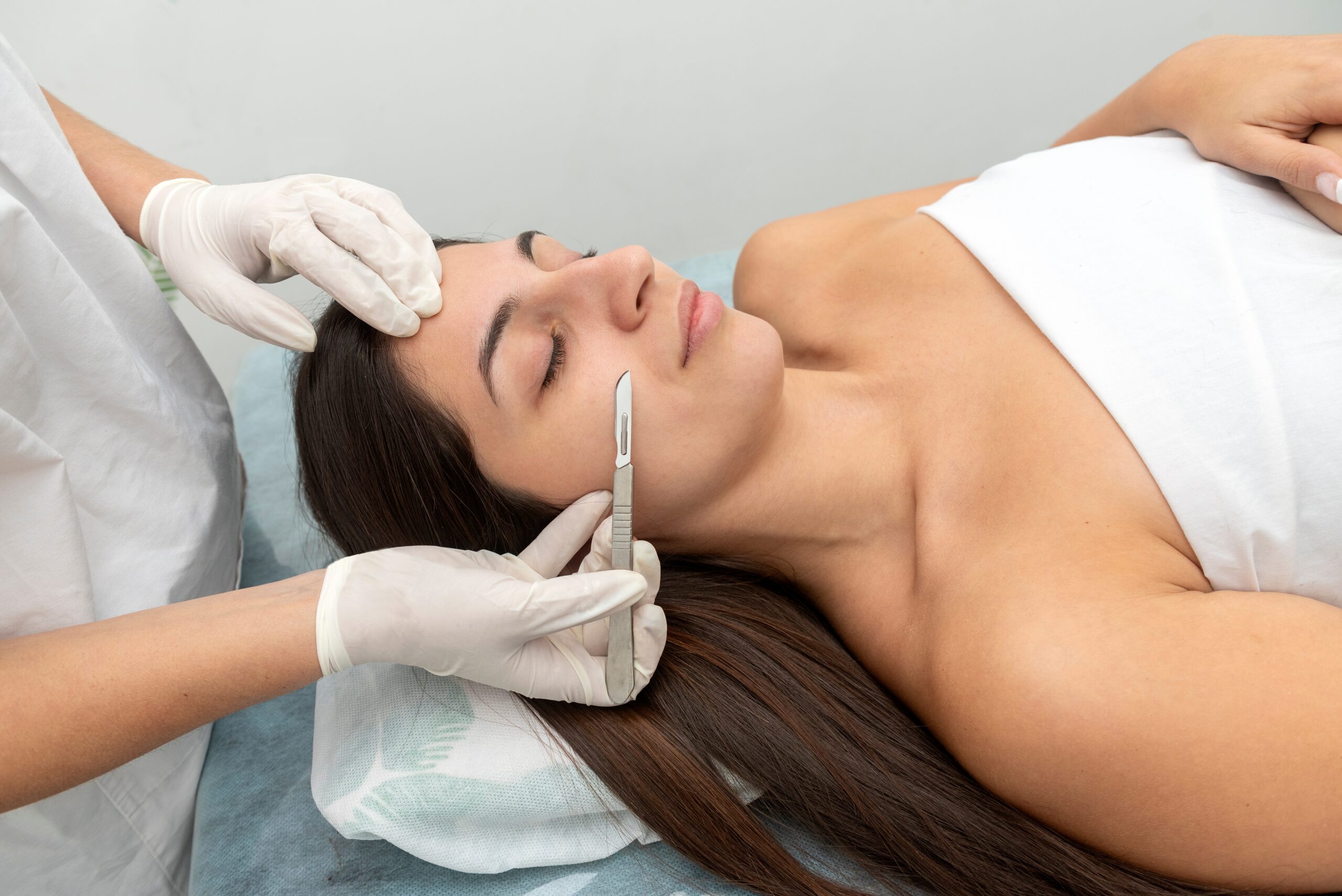 Woman receiving dermaplaning treatment on her face for smoother, more radiant skin