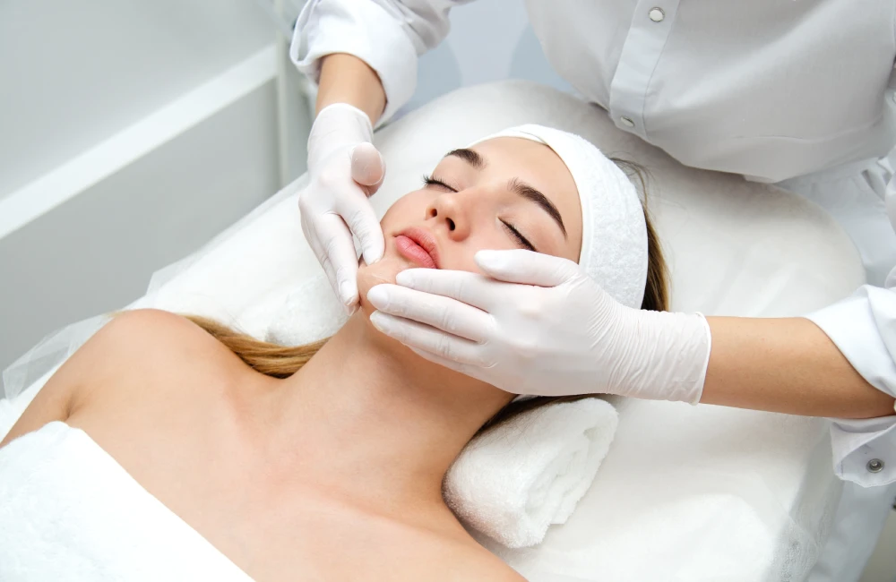 Esthetician performing acne facials treatment in a med spa.